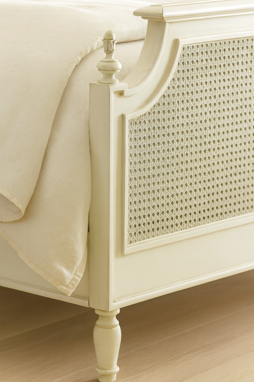 Cream-colored bed with wicker headboard on a wooden floor