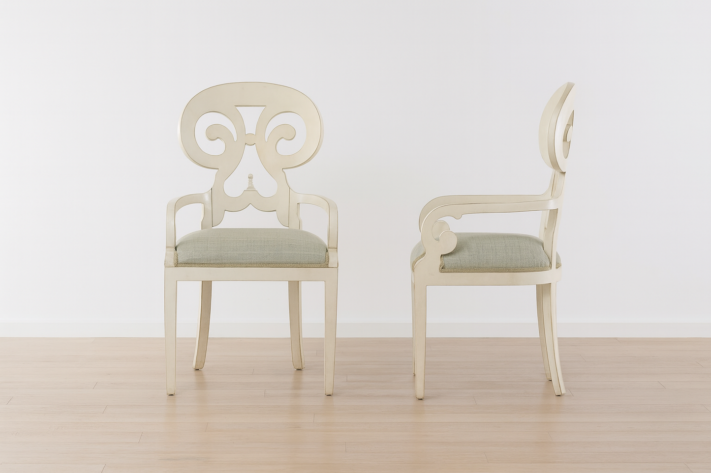 Two white chairs with decorative backrests on a wooden floor.