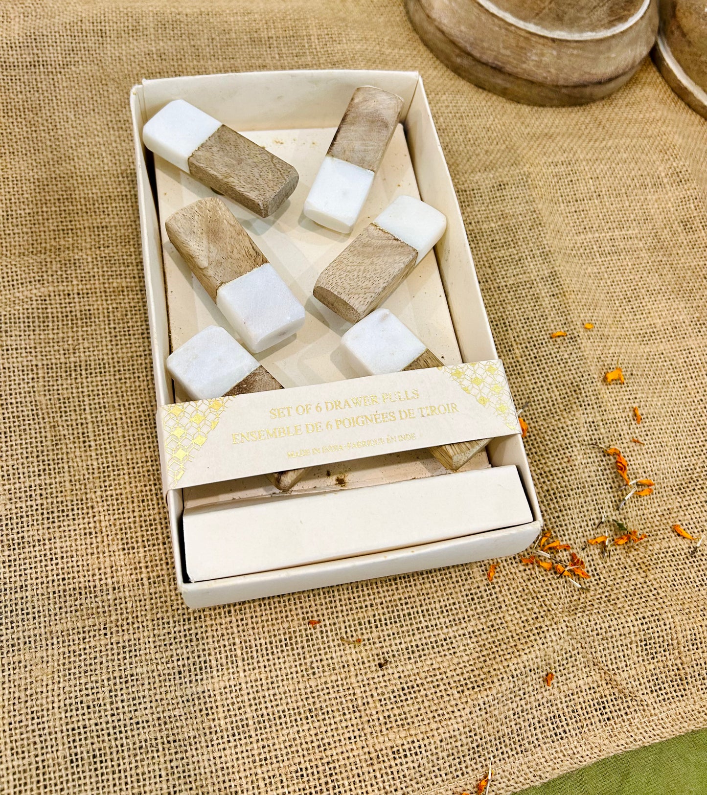 Set of wooden drawer pulls in a box on a textured fabric background