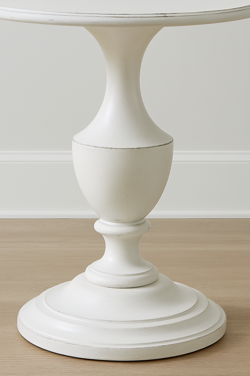 White pedestal table on a wooden floor with a white wall background