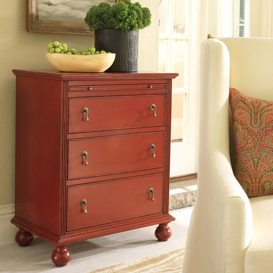 Red dresser with three drawers in a living room setting