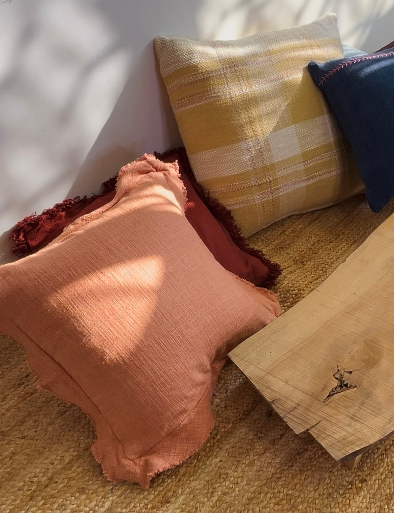 Textured pillows in various colors on a textured surface