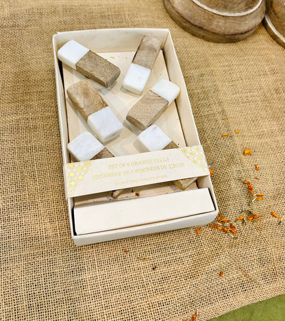 Set of wooden drawer pulls  in a box on a textured fabric background